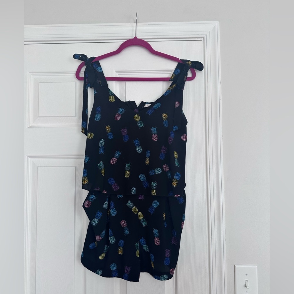 Black pineapple print romper with bow tie shoulders.